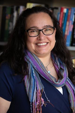 photo of Ariana Ochoa Camacho smiling in a library