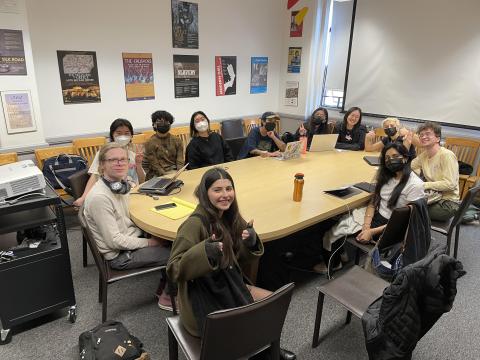 Image of LABOR 480 students sitting around a table and facing the camera with smiles and thumbs up.